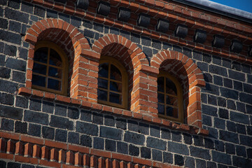 Naklejka premium Old brick house arched windows in the winter time.