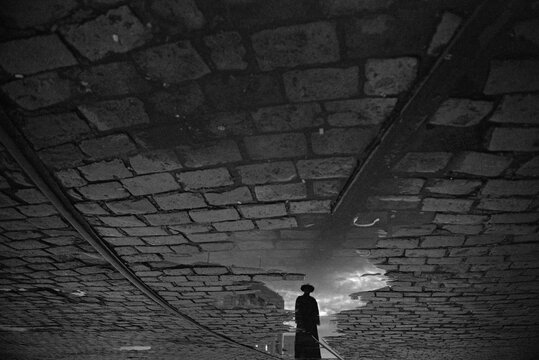 Priest reflected in a puddle in Salvador da Bahia