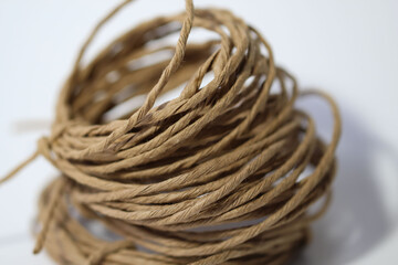 Close-up of a roll of kraft twine on a white background as a natural background or texture