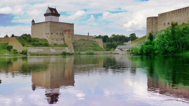 Touristic attraction city scenery, historic medieval landmarks on Russian Estonian border, Narva Herman castle and Ivangorod fortress alongside Narva river, cloudy sky horizon