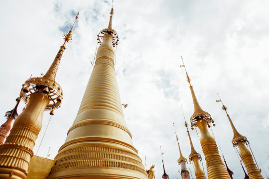 Low angle view of stupas at Shwe Indein Pagoda against cloudy sky