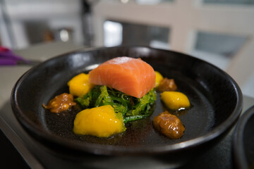 Kaltgeräucherter Lachs auf Wakame–Algen Salat 
an Mango Kompott und Räuchercreme
