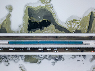One train on Kiev metro bridge across the frozen Dnieper river. Textured pattern on ice. Aerial...