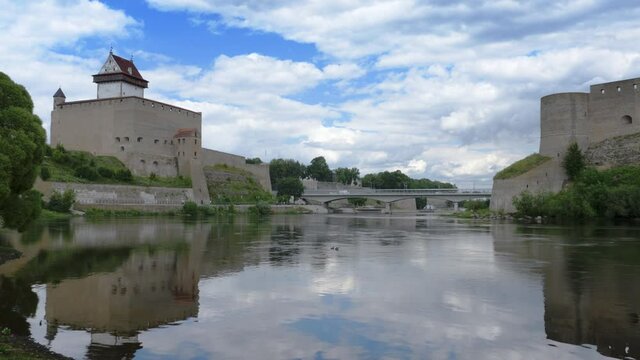 Historic touristic attractions on Russian Estonian border, Narva Herman castle and Ivangorod fortress on banks of Narva river, cloudy sky horizon vista