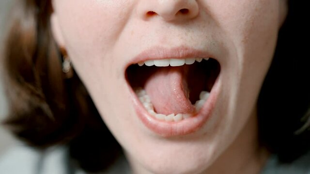 Articulatory gymnastics for the tongue. Close-up speech therapist shows language exercises.