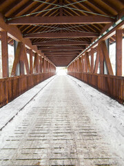 Die Holzbrücke im Winter über den Fluss