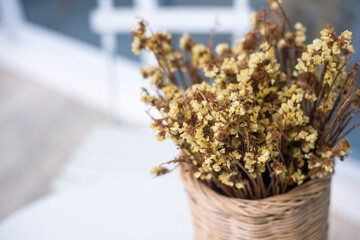 Dried flower in a vase made of Rattan on white table, close up. Marsh Rosemary, Sea Lavender or Statice flower background. (Scientific name - Limonium sinuatum)