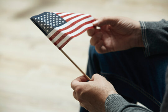Midsection of man holding small American Flag