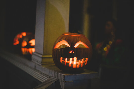 Close-up of illuminated jack o lanterns on retaining wall