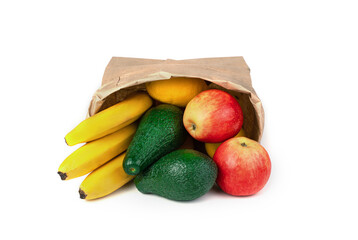 Avocados, bananas and apples lie in an inverted kraft bag on a white background. The concept of natural, dietary products.