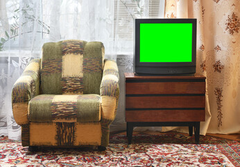 Antique TV with green screen on an antique wooden cabinet, old design in a house in the style of the 1980s and 1990s.Interior in the style of the USSR.