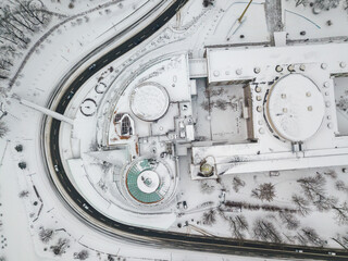 Snowy Kiev. A curved road near a house with a round roof. Aerial drone view. Winter snowy morning.