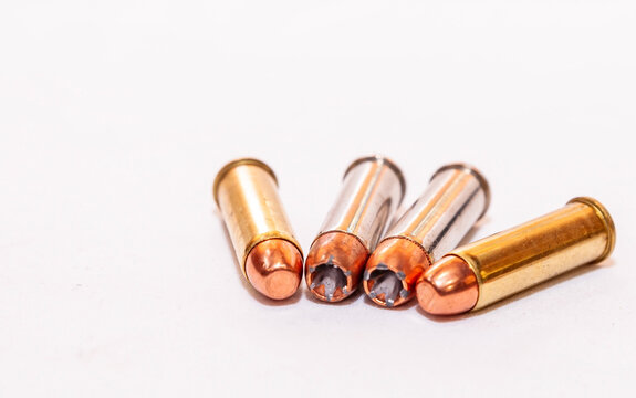 Four 38 special bullets, two hollow points and two full metal jackets on a white background