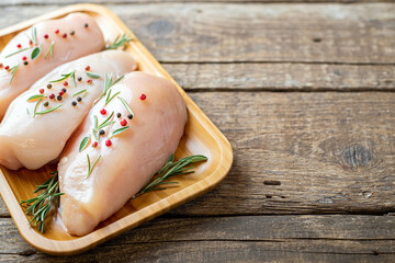 Chicken fillet with herbs and spices on wooden table Flat lay. Chicken meat with ingredients for cooking. Copy space