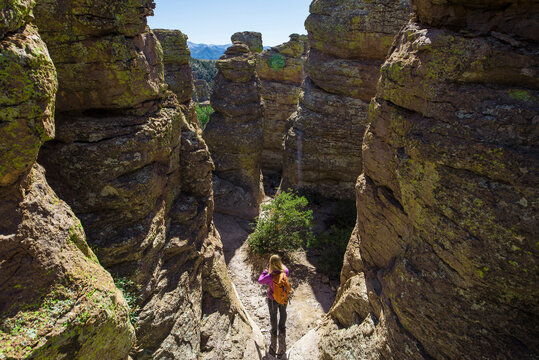 High angle view of woman with backpack standing amidst rocks during sunny day