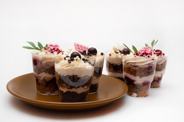 Trifles portioned mini cakes on plate. Layered trifle dessert with whipped cream and chocolate.