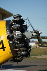 restored old yellow biplane with one engine per propeller