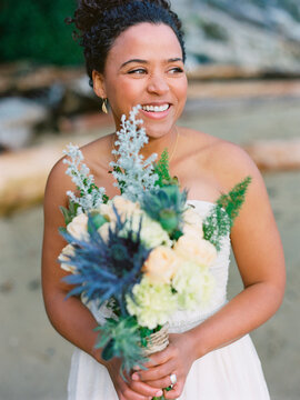 Beautiful bide with the bridal bouquet at the beach