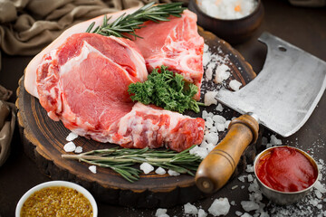 Raw meat with spices in a composition with kitchen accessories.