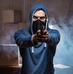 Aggressive manwith gun wearing face mask
