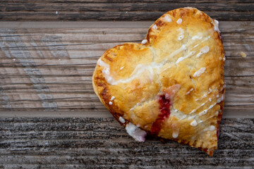 Heart-shape Cherry Hand-Pie on a Wood Texture Background