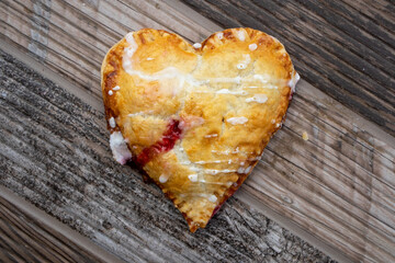 Heart-shape Cherry Hand-Pie on a Wood Texture Background