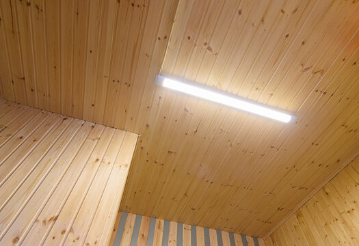 View of a ceiling from a wooden lining with an included LED daylight lamp