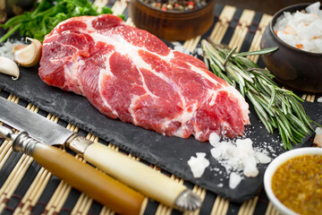 Raw meat with spices in a composition with kitchen accessories.