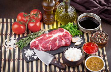 Raw meat with spices in a composition with kitchen accessories.