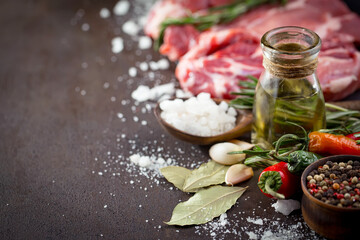 Raw meat with spices in a composition with kitchen accessories.