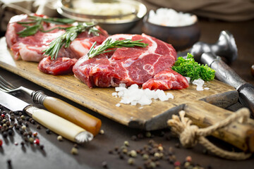 Raw meat with spices in a composition with kitchen accessories.