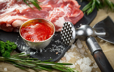 Raw meat with spices in a composition with kitchen accessories.