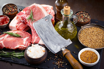 Raw meat with spices in a composition with kitchen accessories.