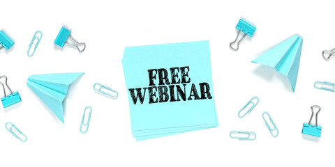FREE WEBINAR written on a blue sticker on a white background with blue paper clips and paper airplanes.