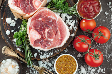 Raw meat with spices in a composition with kitchen accessories.