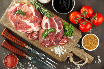 Raw meat with spices in a composition with kitchen accessories.