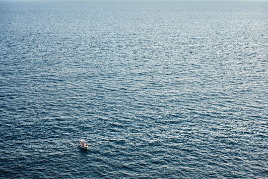 Distant boat in boundless blue sea