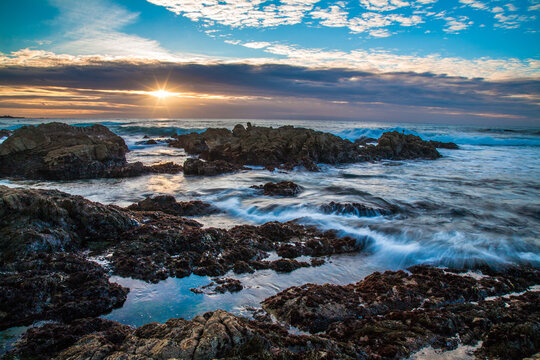Sunset  and waves on rocks at Asilomar State Beach, Monterrey California