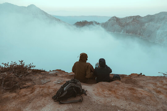 Two hikers sitting and looking at Ijen lake