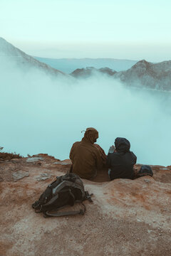 Two hikers sitting and looking at Ijen lake