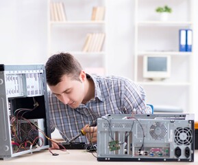 Young technician repairing computer in workshop