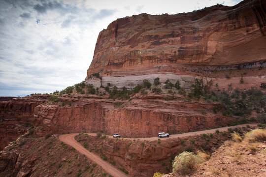 Two vehicles drive Shafer Trail, a 4x4 wheel road, Canyonlands NP