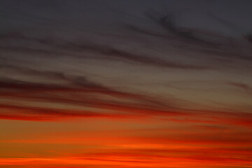 Dramatic red and orange sky and clouds abstract background. Red-orange clouds on sunset sky. Warm weather background.