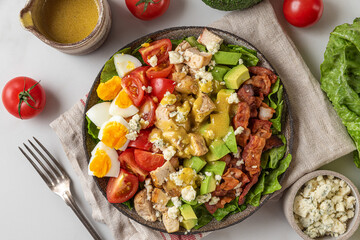 Cobb salad. Classic American salad with bacon, grilled chicken, eggs, avocado, cheese and vinaigrette dressing. top view