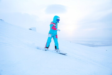 Fototapeta na wymiar woman snowboarder is snowboarding from the mountain 