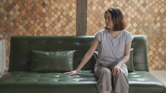 lonely pity asian female on memorable sofa couch passive looking and feeling missing someone at vintage home. sad woman feel depression. 