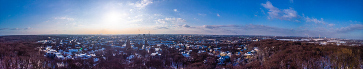 Fototapeta na wymiar View of the snow-covered skyline of Duisburg at sunset from above