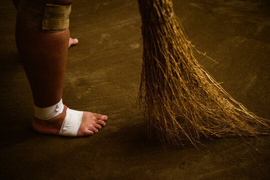 Low section of wrestler sweeping field in sumo beya
