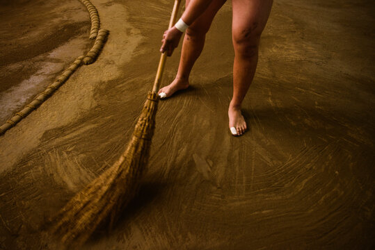 Low section of wrestler sweeping field in sumo beya