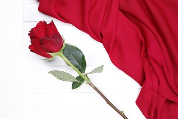 Czerwona róża i czerwona tkanina na białym blacie - obrazy, fototapety, plakaty